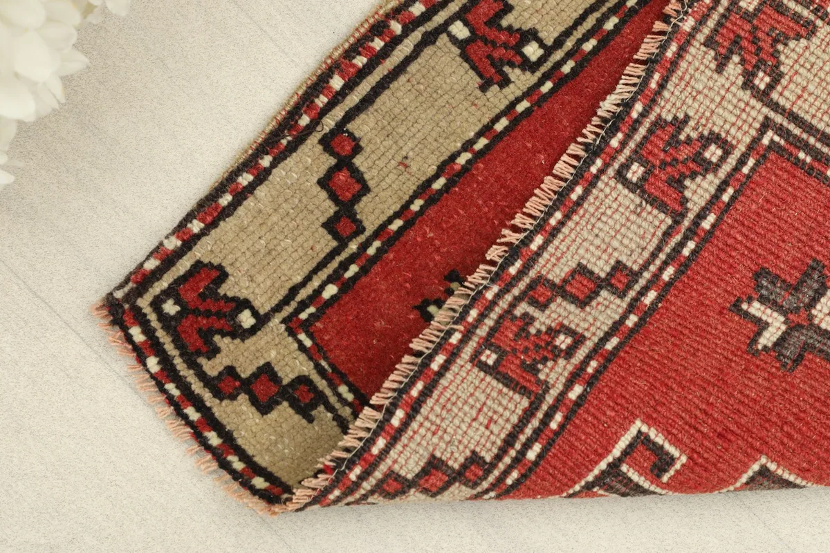 Rug partially folded, displaying the wool pile and cotton foundation.