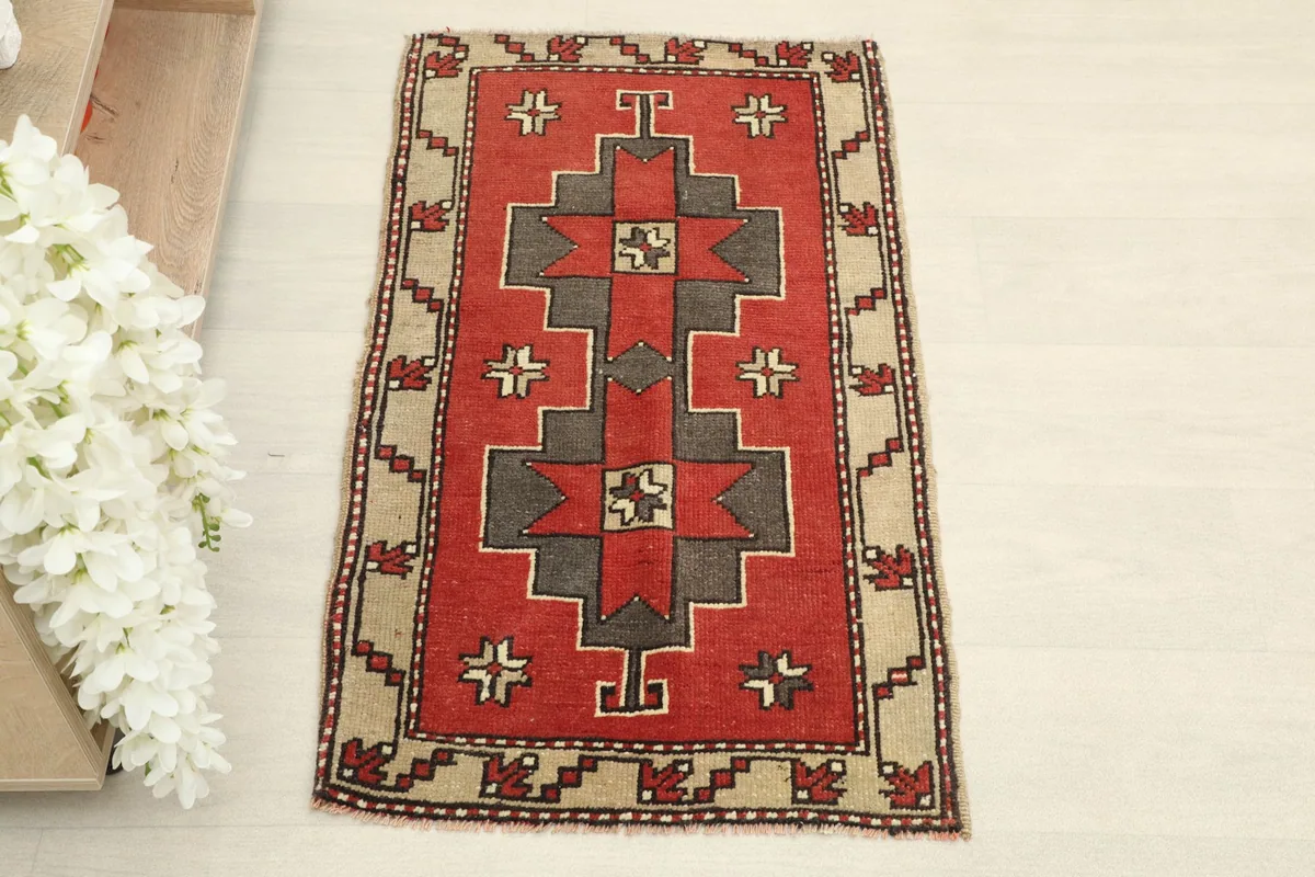 Overhead view of the red, tan, and charcoal geometric vintage doormat.