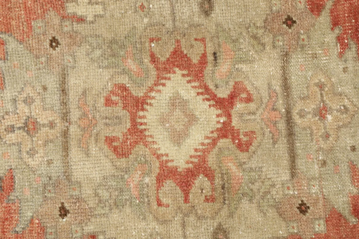 Close-up detail of the central beige and rust medallion motif with geometric patterns.