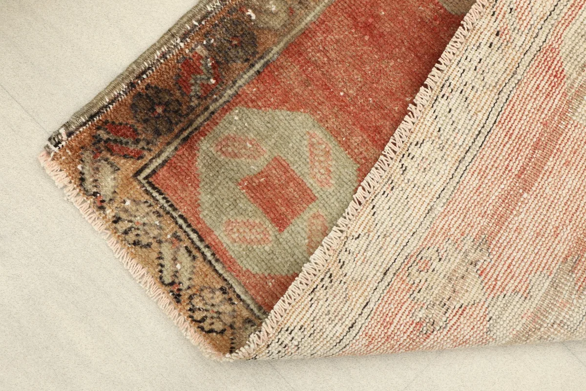 View of the rug folded to show the cotton foundation and hand-knotted construction.