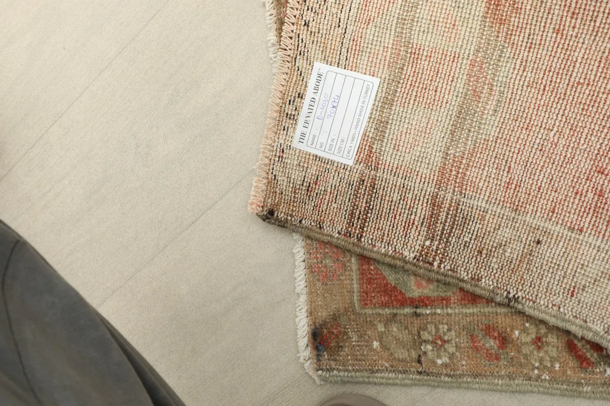Underside of the rug, displaying the tightly woven cotton foundation and a product label.