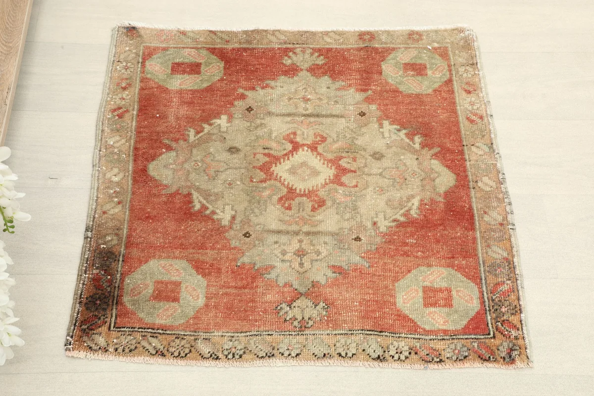 Direct overhead shot showcasing the rust and beige geometric medallion design of the small rug.