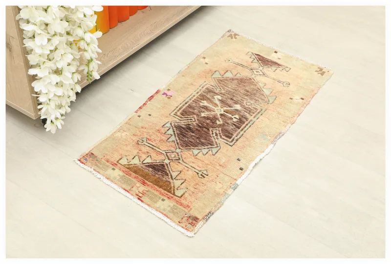 Full top view of the 1'5" x 2'11" beige and rust tribal doormat on a white floor.