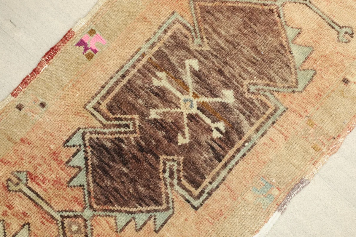 Close-up detail of the central brown geometric motif and surrounding beige and rust colors.