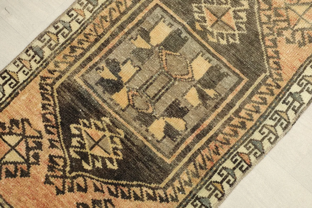Close-up detail of the central charcoal medallion and surrounding tan field with geometric patterns.