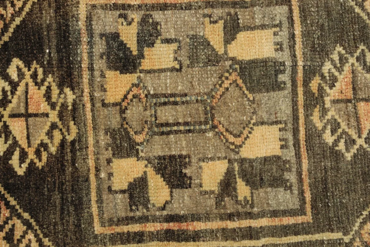 Detailed view of the intricate geometric motifs within the charcoal medallion, showing color variations.
