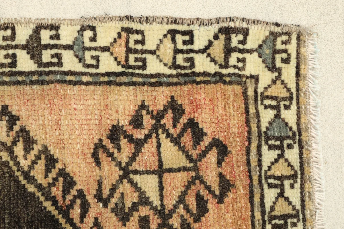 Close-up of the rug's border and corner, highlighting the hand-knotted texture and fringe.
