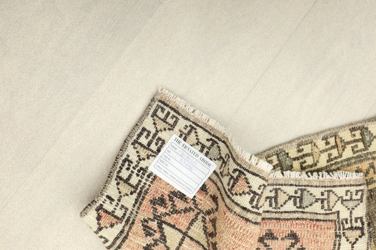 Back of the rug with a label, showing the cotton foundation and hand-knotted construction.