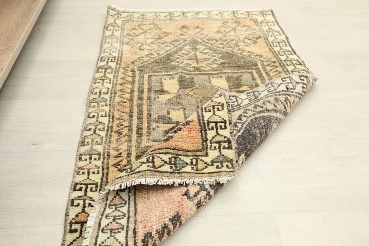 The rug partially folded, revealing the back and the density of the hand-knotted wool.