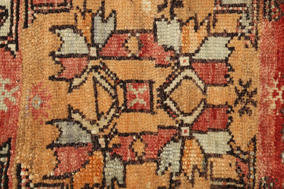 Close-up detail of the intricate geometric motifs and color variations in the rug's center