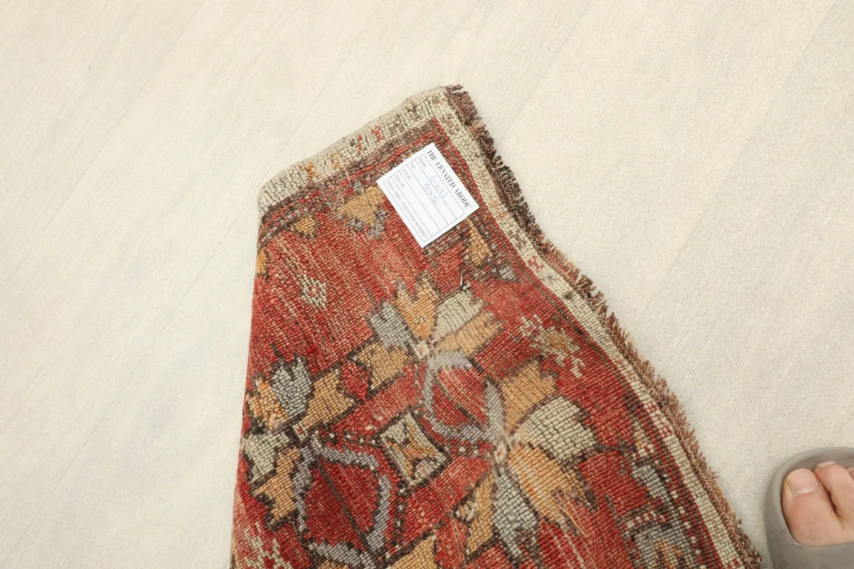 View of the rug's back, showing the knotting structure and a small label