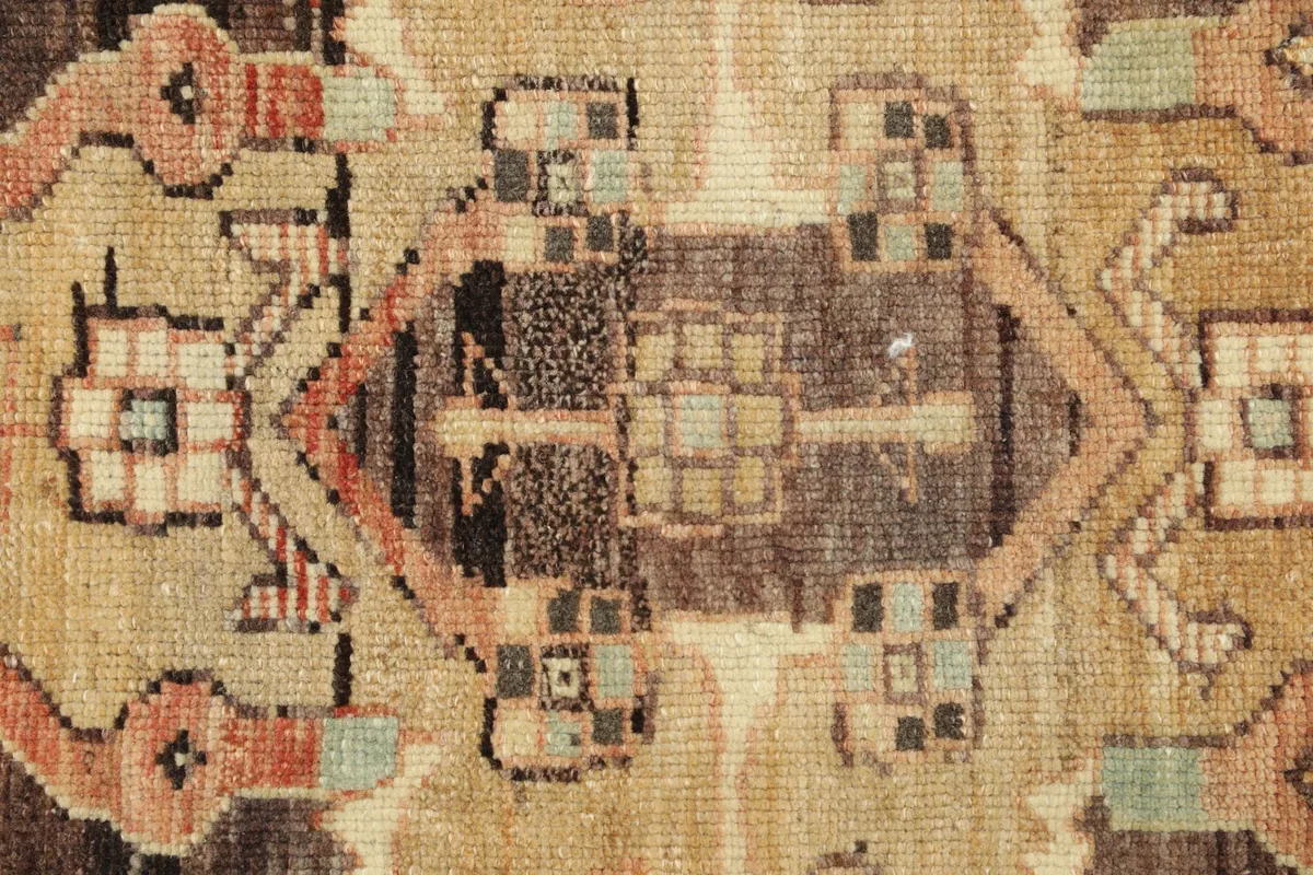 Close-up detail of the rug's intricate tribal motifs and the varied texture of the wool pile