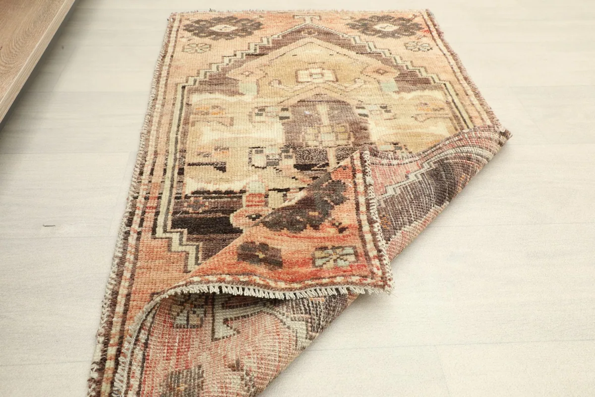 The vintage rug partially folded, revealing the reverse side and overall thickness