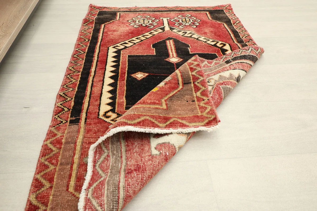 Angled view of the rug with one corner folded back, displaying the overall design and texture