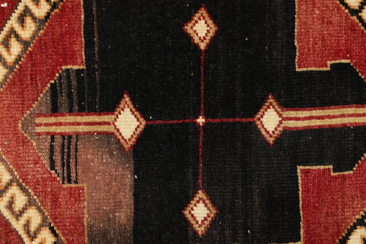 Detailed close-up of the black and beige diamond motifs within the rug's central design