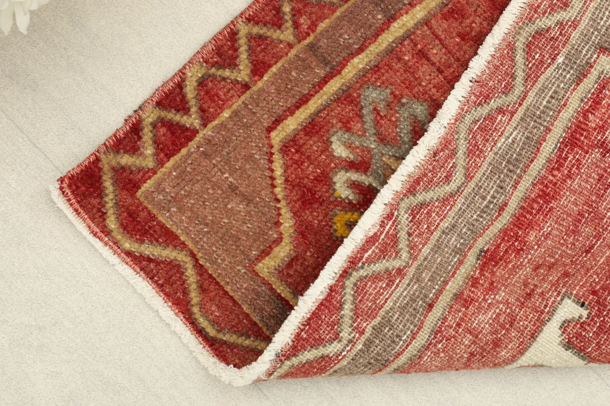 View of the rug folded to show the thickness and texture of the hand-knotted wool pile