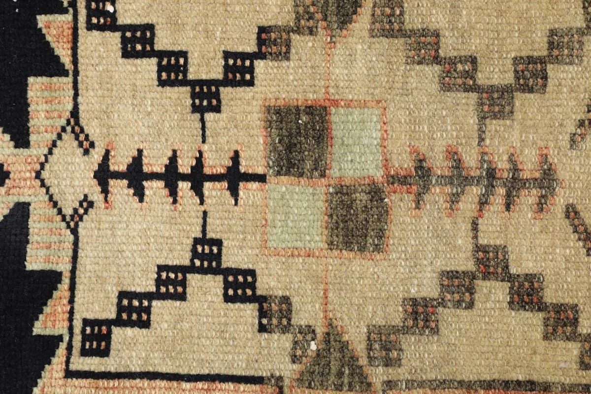 Detailed view of the intricate geometric patterns and color variations in the rug's pile.