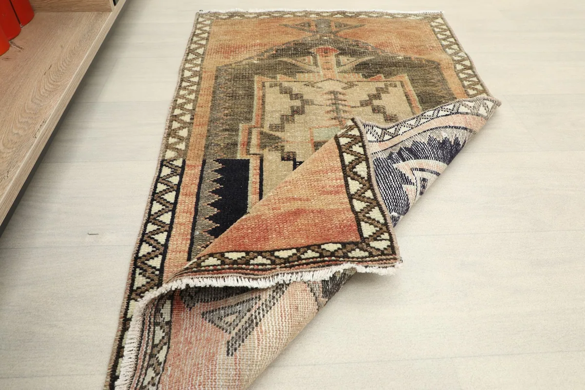 The rug partially folded, showing the flexibility and the back of the hand-knotted cotton foundation.