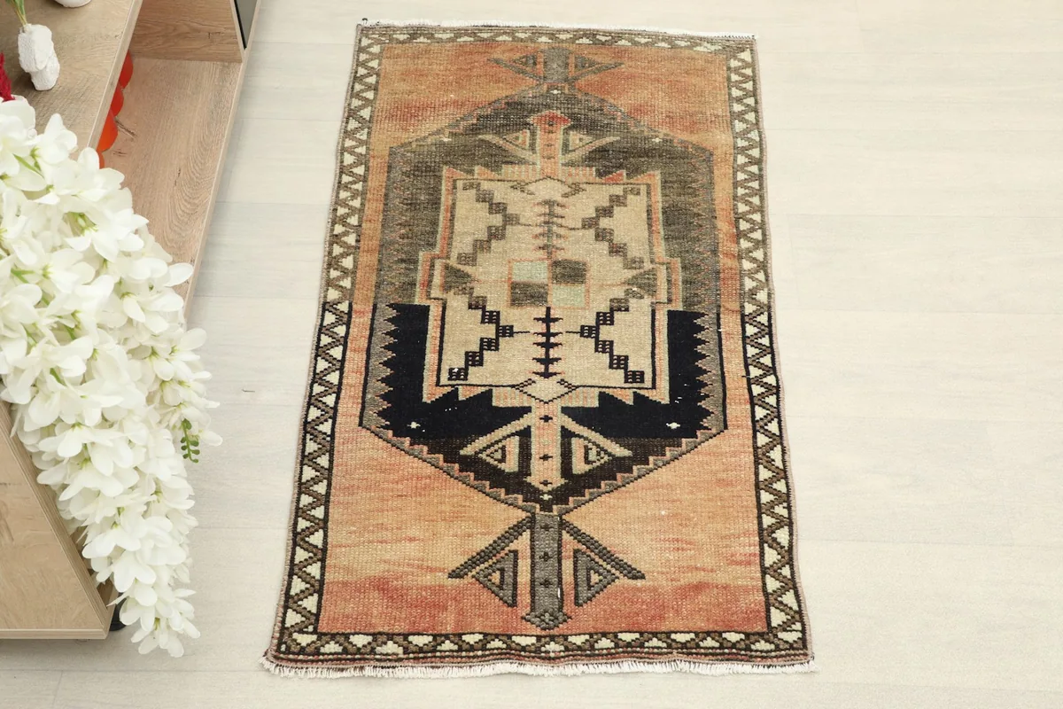Overhead view showing the complete design of the rose, navy, and beige hand-knotted area rug.