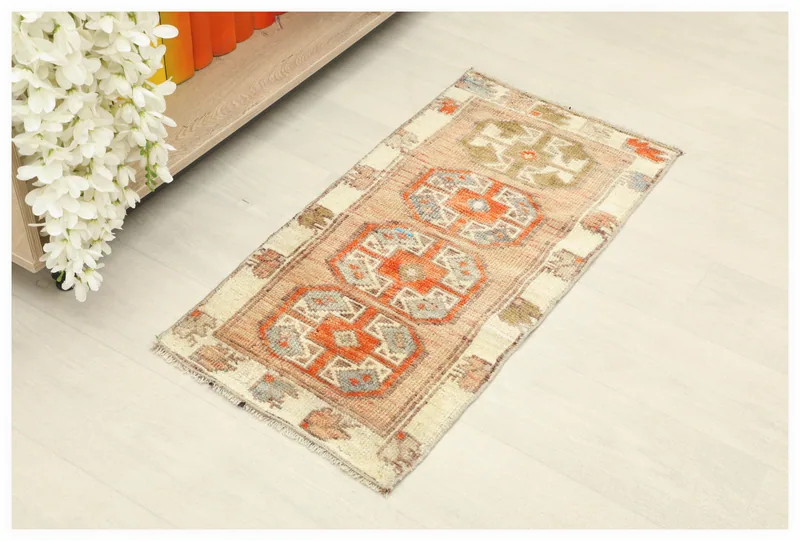 Full overhead view of the rust and beige geometric vintage Anatolian doormat on a white background.