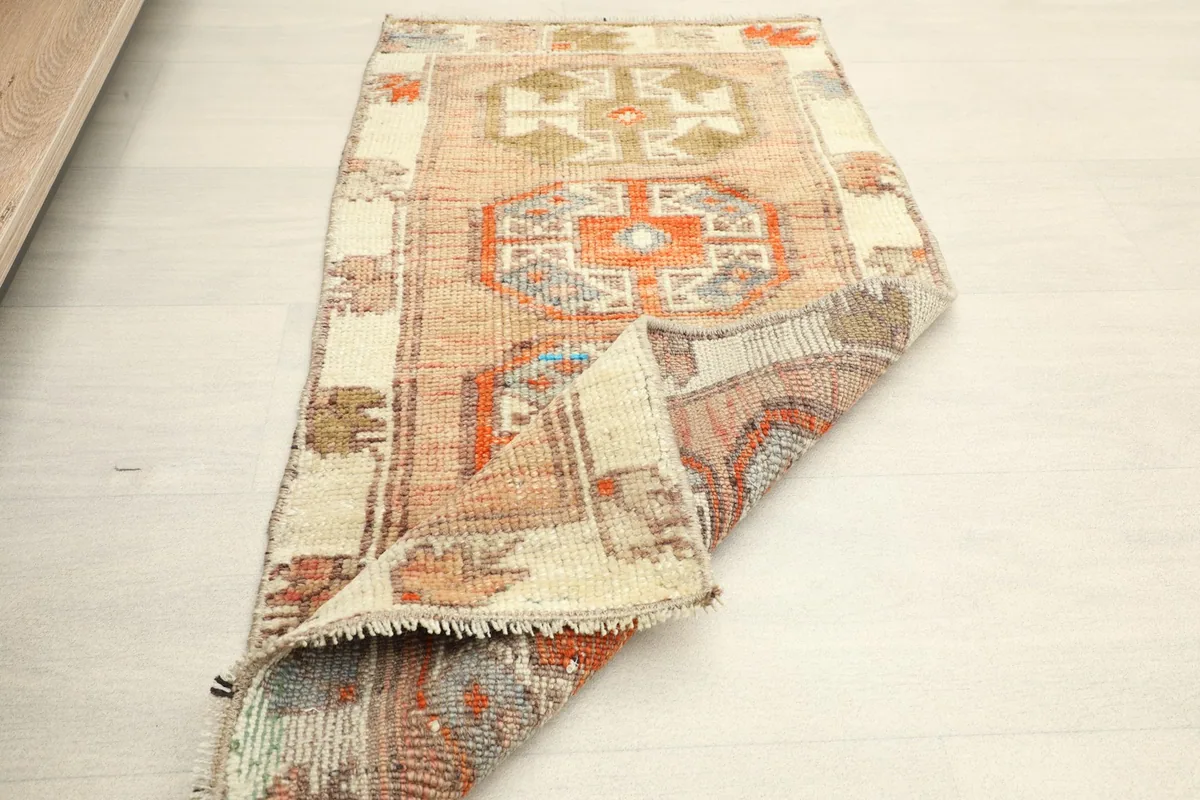 Angled view of the entire doormat, partially folded, showing its rectangular shape.