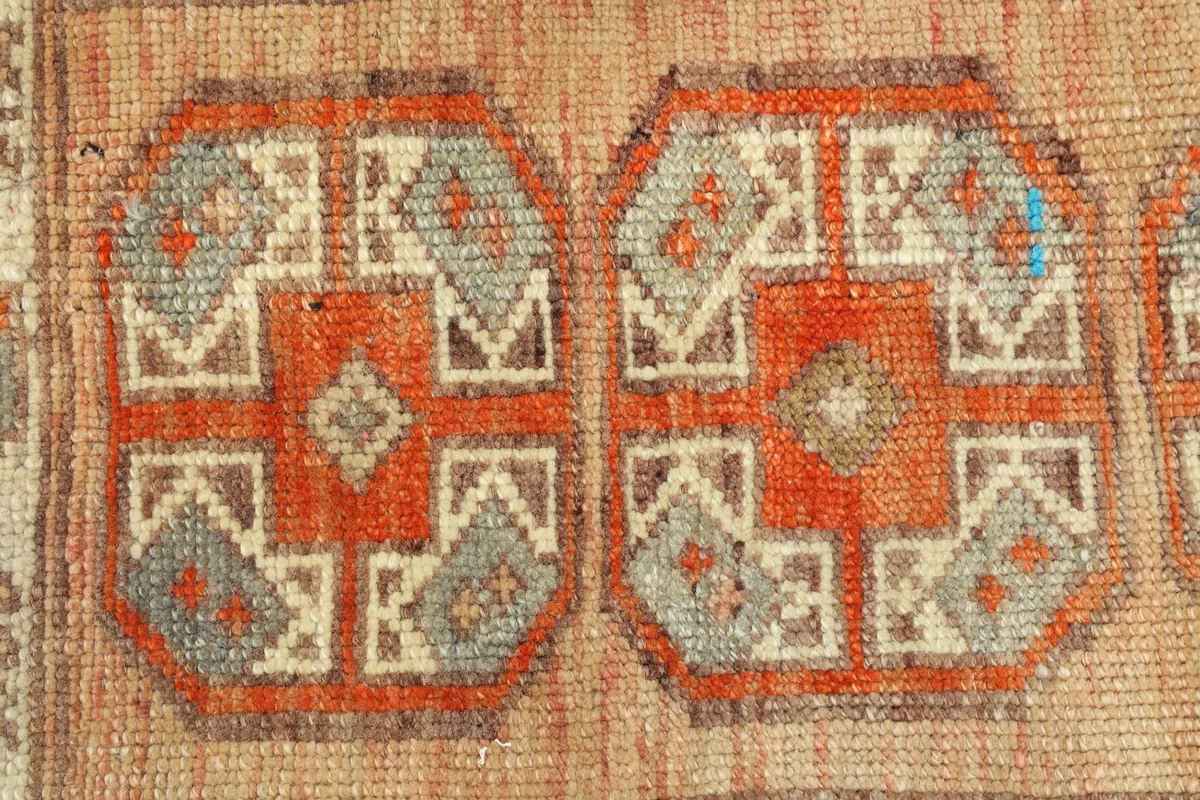 Close-up detail of the central geometric motifs and the woven texture of the wool pile.