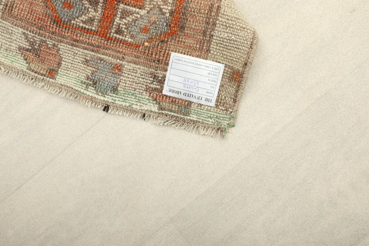 View of the back of the doormat, displaying the knotting work and a label.