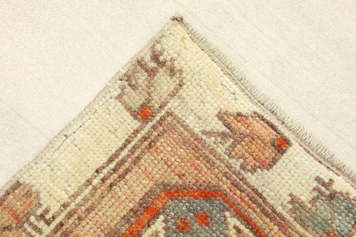 Close-up of a corner of the doormat, showing the beige border and fringe detail.