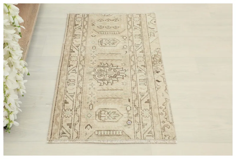 Full top view of a 1'7" x 2'10" beige vintage Anatolian doormat with brown tribal motifs.
