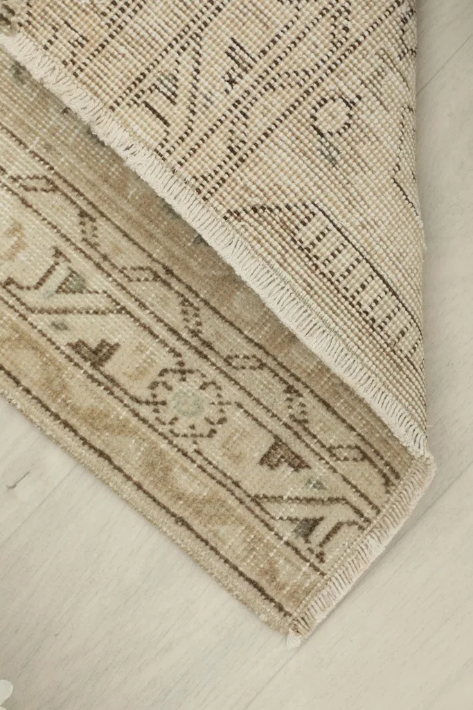 View of the back of the rug, showing the knotting and cotton foundation.