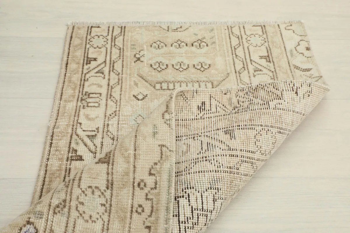 Rug partially folded, revealing the reverse side and knotting detail.