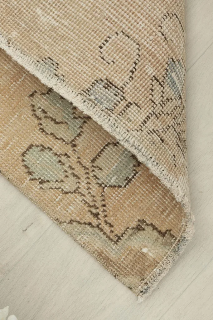 Rug corner folded back, revealing the wool pile and cotton foundation