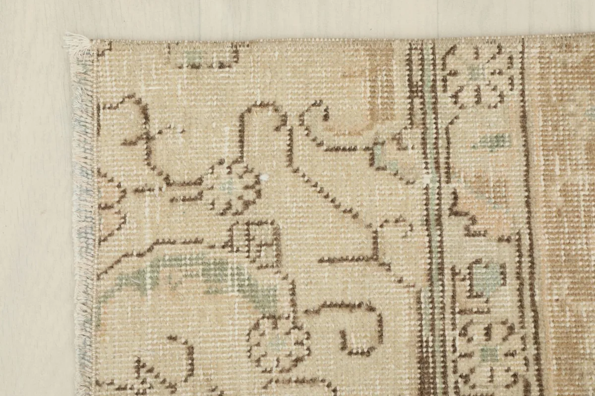 Close-up of the rug's edge, showing the subtle border design and fringe