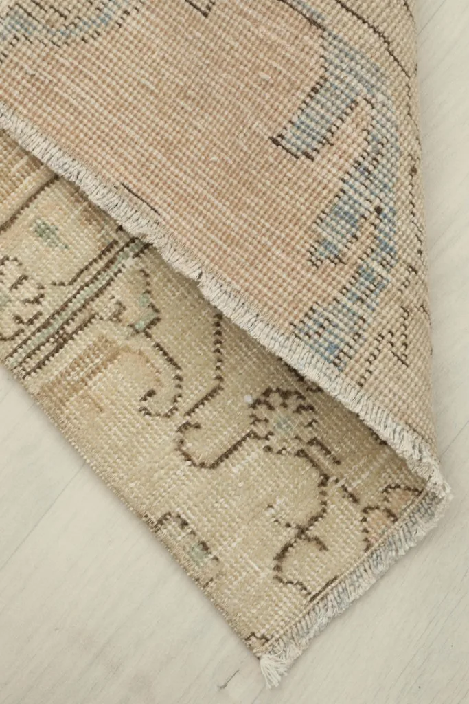 View of the back of the rug, showing the cotton foundation and hand-knotted construction