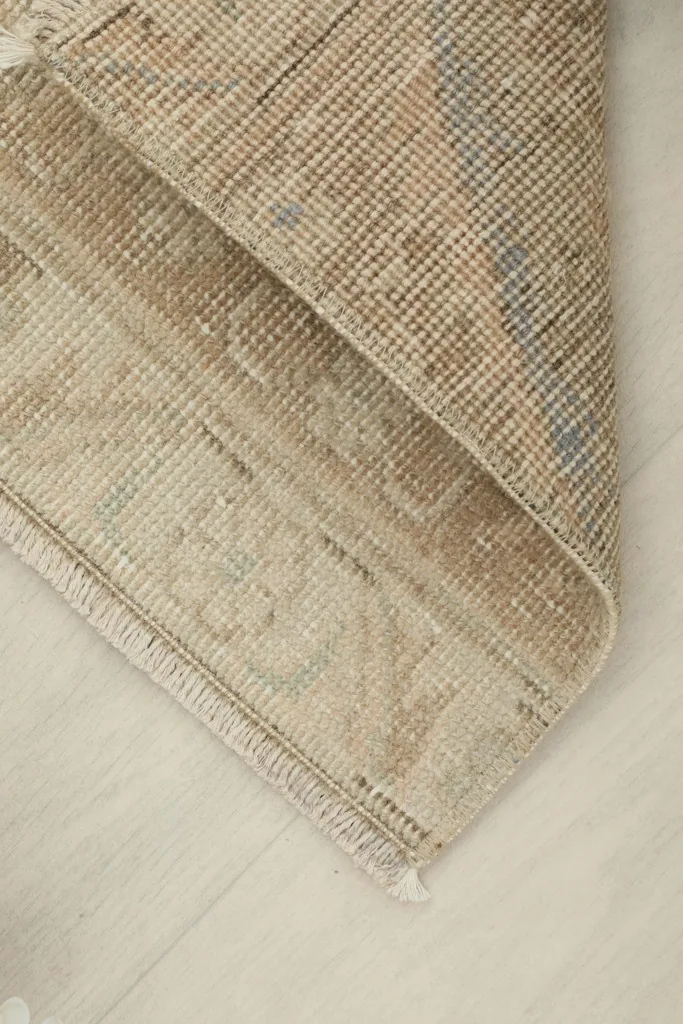 View of the rug's underside, revealing the hand-knotted cotton foundation