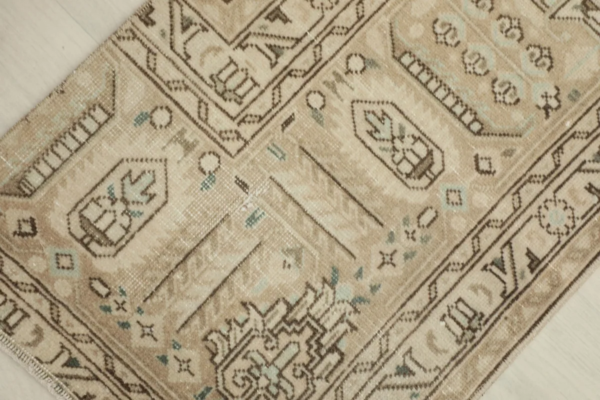 Detailed view of the rug's geometric motifs and subtle color variations, including light green and blue accents.