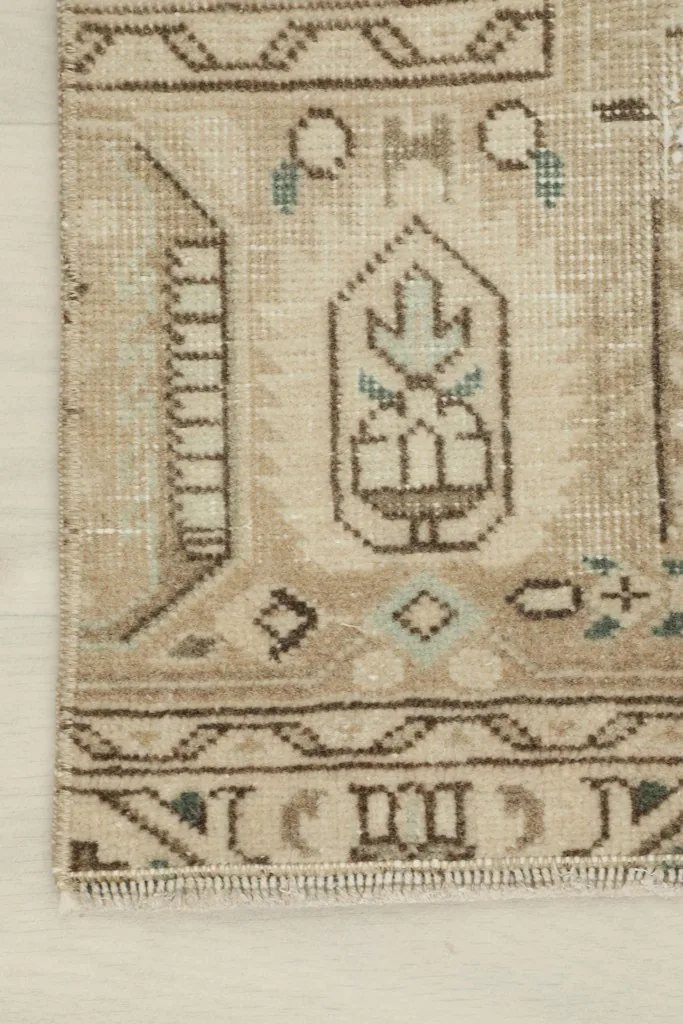Corner detail of the rug, showing the worn texture and traditional tribal patterns.