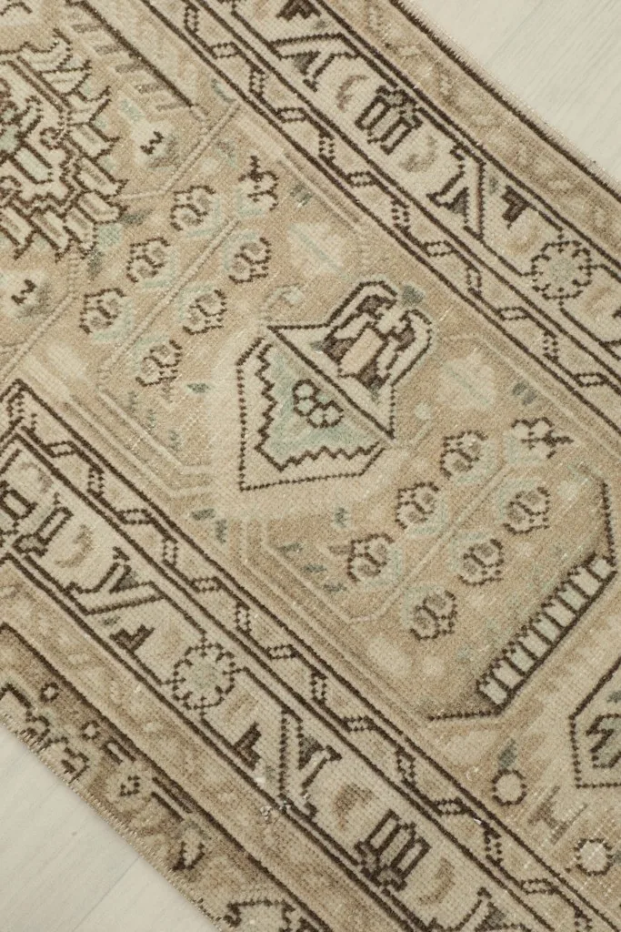 Detailed view of the central geometric motif and surrounding patterns in beige and brown.