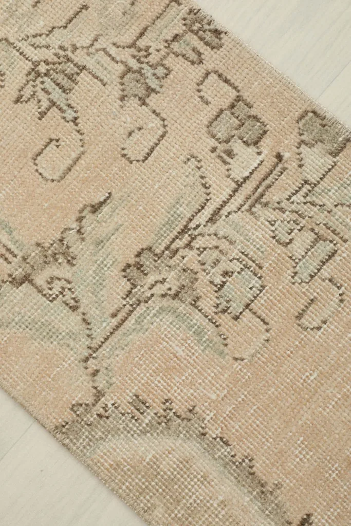 Detailed view of the intricate floral and geometric patterns in shades of brown and gray.