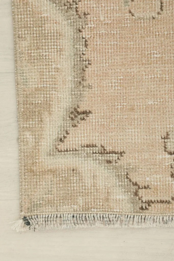 Close-up of the rug's edge, showing the low pile and a hint of the fringe.