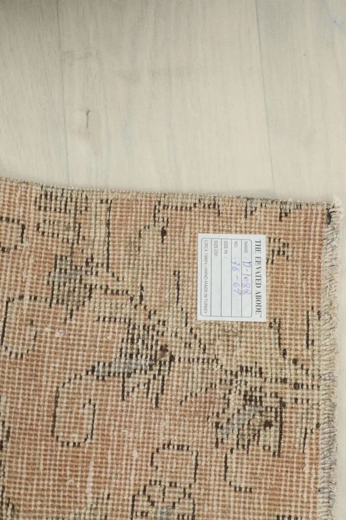 Backside of the rug with a size label, showing the hand-knotted details of the foundation.