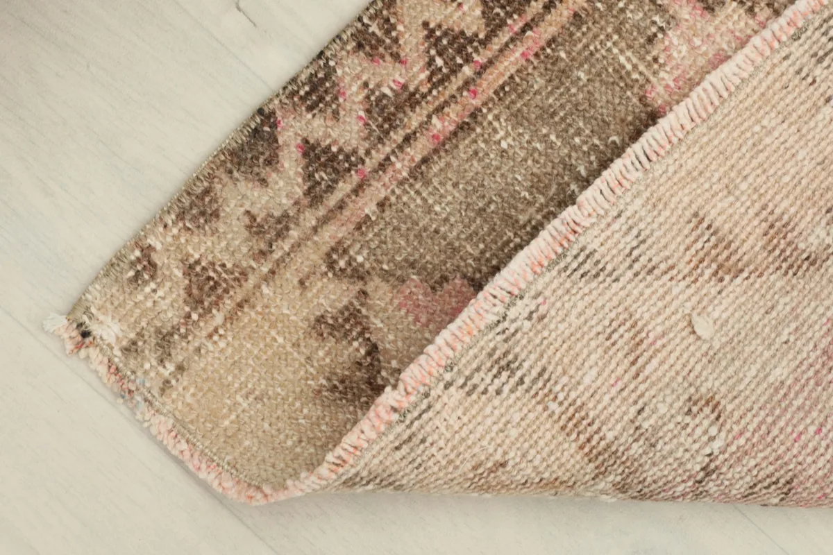 Corner of the rug folded back to display the reverse side and the cotton foundation