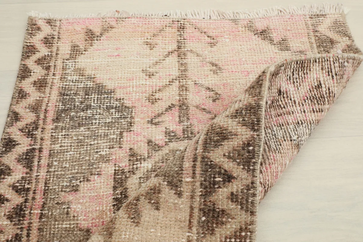 Rug partially folded, showcasing the full pattern and the flexibility of the vintage textile
