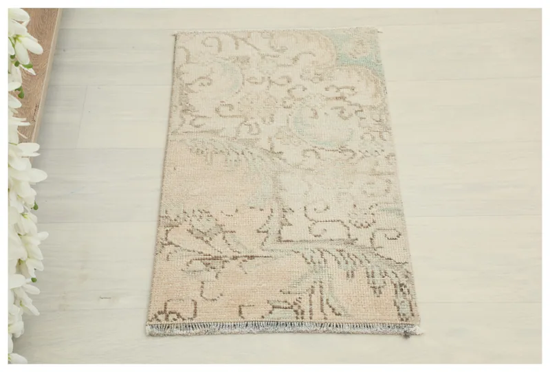 Full overhead view of the 1'3" x 2'3" beige and tan vintage Anatolian rug on a white background.