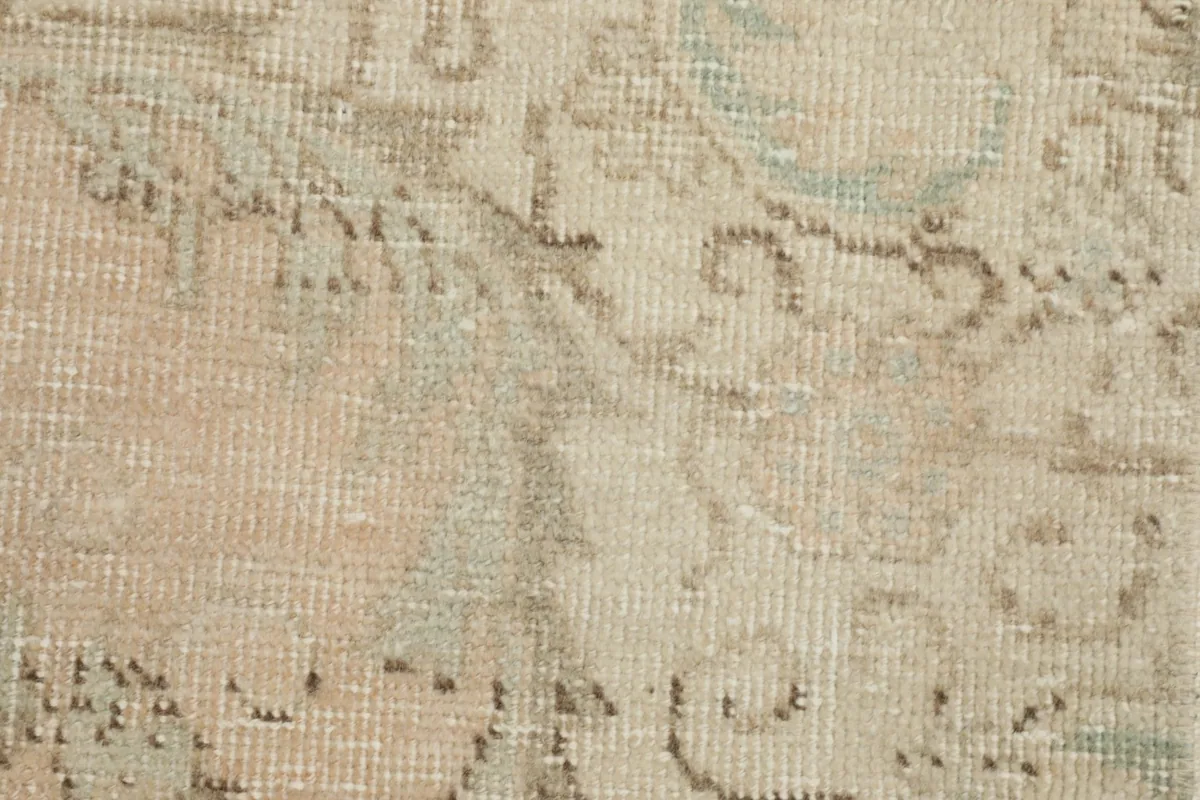 Close-up of the low wool pile, revealing the distressed look and intricate hand-knotted structure.