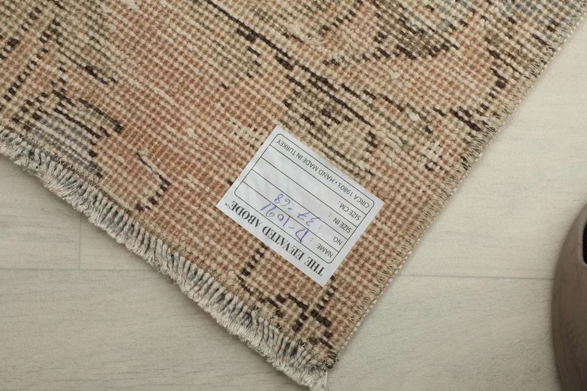 Close-up of the back of the hand-knotted wool rug, showing the dense weave and a product label.
