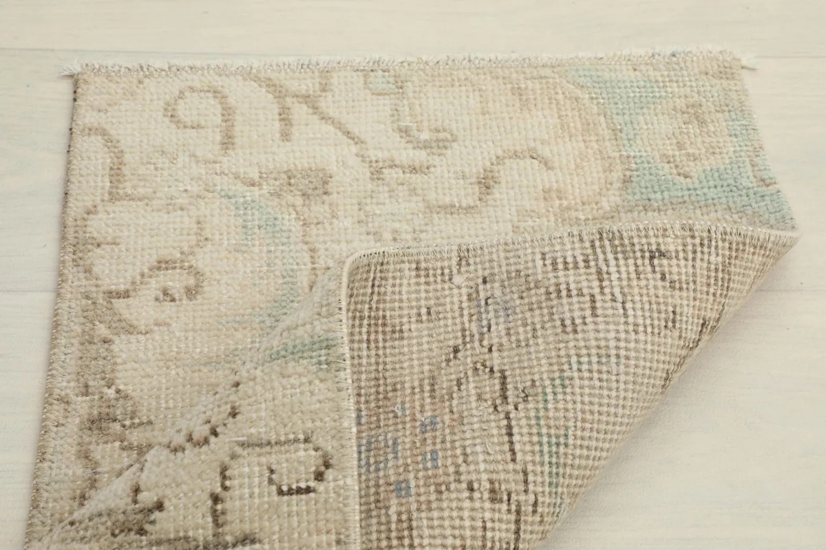Another view of the rug folded, emphasizing the back weave and the character of the vintage piece.