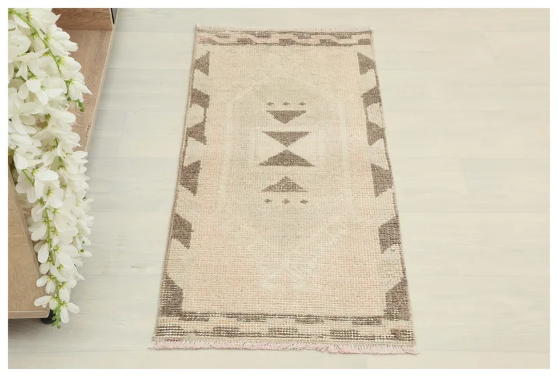 Full overhead view of the beige and brown vintage Anatolian doormat on a white background