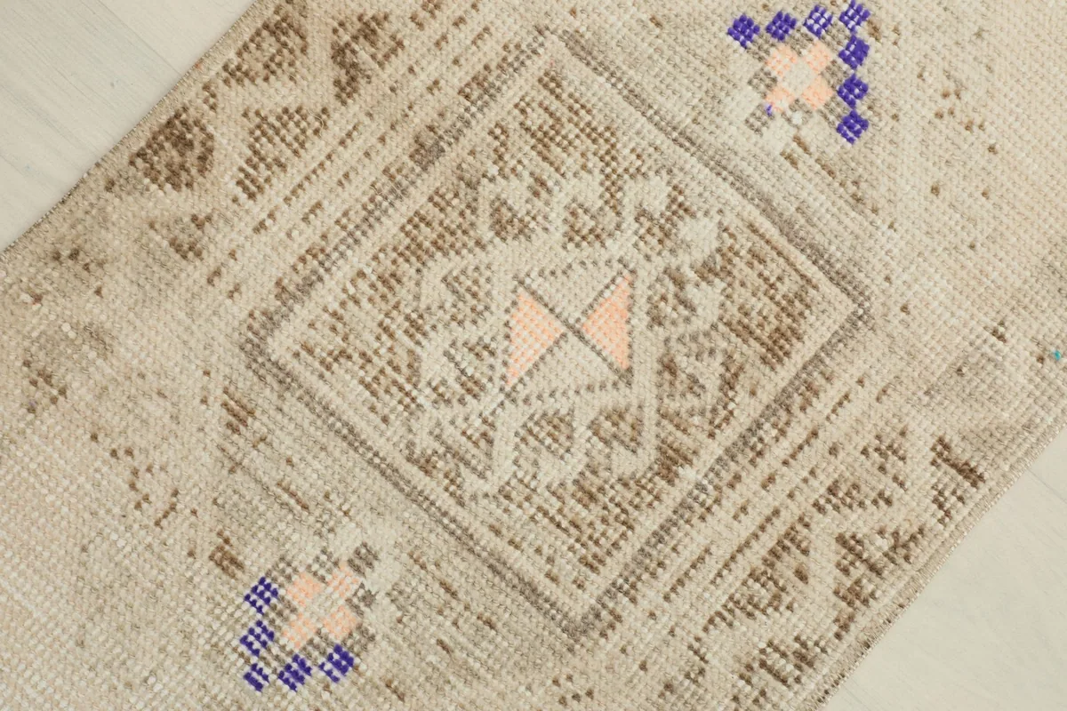 Detailed angled view of the central geometric pattern in brown and beige with a rose accent