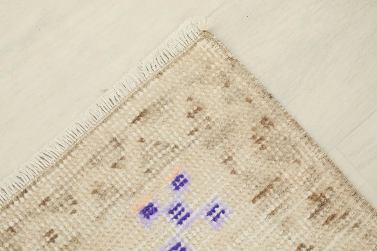 Close-up of the rug's edge, showcasing the hand-knotted structure and fringe